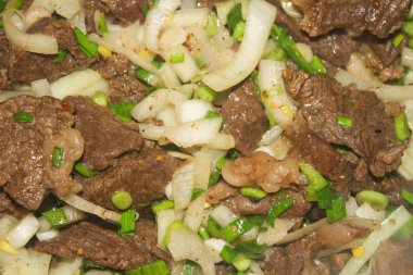 Sulu biftek, kavrulmuş tecrübeli, Yeşiller ve soğan ile kısık ateşte.