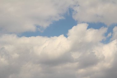 Mavi gökyüzüne karşı beyaz bulutlar.