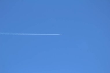 Uçak bir iz bırakarak gökyüzünde uçar.