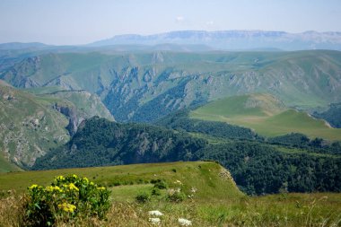 Kafkas Dağları, yüksek dağlar, yeşil çayırlar ve karla kaplı dağlar.
