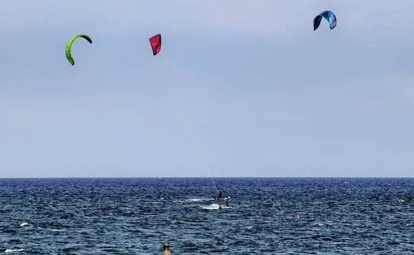 意大利利古里亚的 Albenga 2018年7月 在阿尔本加的海洋上的风筝冲浪 色彩鲜艳的帆活跃在蓝天上 在水面上 木板的痕迹呼啸着经过帆 — 图库照片