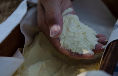 Bir çocuğun yardım durum buğday unu ile dolu. Bir ahşap kutu altında un ile dolu. Unundan ortaya çıkan beyaz bir kumaş kenarı boyunca görülebilir.