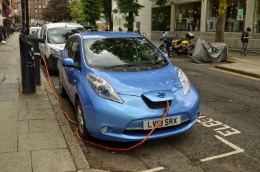 Londra, Birleşik Krallık, Haziran 2018. Londra 'nın tarihi merkezine park etmiş bir Nissan Yaprağı. Otopark elektrikli araçlar için ayrılmıştır ve hızlı şarj kolonu ile donatılmıştır..
