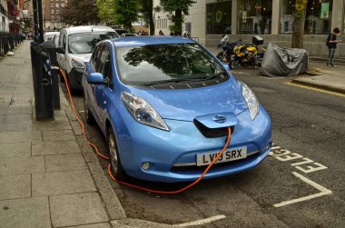 Londra, Birleşik Krallık, Haziran 2018. Londra 'nın tarihi merkezine park etmiş bir Nissan Yaprağı. Otopark elektrikli araçlar için ayrılmıştır ve hızlı şarj kolonu ile donatılmıştır..