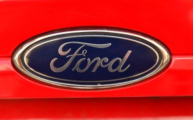 Turin, Piedmont region, Italy, July 2018. Close up of the Ford logo of a red 1.4 Gpl fiesta. clipart