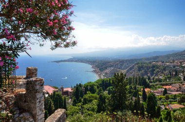 Taormina, İtalya, Sicilya 26 Ağustos 2015. Yunan Tiyatrosu, denize doğru gelen görkemli panorama. Yemyeşil nature, Akdeniz bitki örtüsü, çiçekler. Deniz ve deniz araçları.
