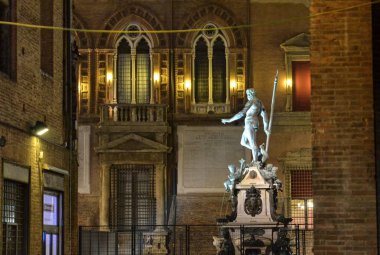 Bologna, Emilia Romagna, İtalya. Aralık 2018. Gece Neptün çeşme, Yılbaşı için, renkli ışıklar ile aydınlatılmış ve onu korumak için çitle çevrili olmuştur.