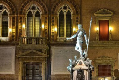 Bologna, Emilia Romagna, İtalya. Aralık 2018. Gece Neptün çeşme, Yılbaşı için, renkli ışıklar ile aydınlatılmış ve onu korumak için çitle çevrili olmuştur.