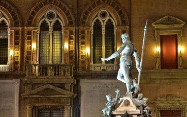 Bologna, Emilia Romagna, İtalya. Aralık 2018. Gece Neptün çeşme, Yılbaşı için, renkli ışıklar ile aydınlatılmış ve onu korumak için çitle çevrili olmuştur.