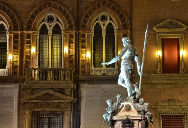 Bologna, Emilia Romagna, İtalya. Aralık 2018. Gece Neptün çeşme, Yılbaşı için, renkli ışıklar ile aydınlatılmış ve onu korumak için çitle çevrili olmuştur.