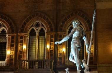 Bologna, Emilia Romagna, İtalya. Aralık 2018. Gece Neptün çeşme, Yılbaşı için, renkli ışıklar ile aydınlatılmış ve onu korumak için çitle çevrili olmuştur.