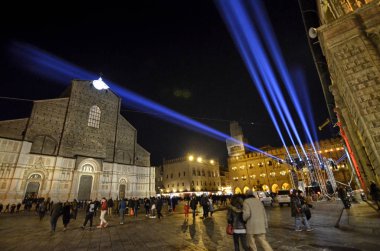 Bologna Emilia Romagna, İtalya. Aralık 2018. Piazza Maggiore için yeni yıl kutlamaları hazırlıkları içinde. Renkli ışıklar karanlık gece gökyüzüne karık. İnsanlar yürüyüş.
