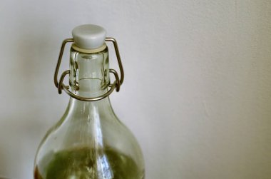 Şeffaf cam şişe tarafsız beyaz zemin üzerinde. Su dolu, kapanış mekanizması conta ve kap.