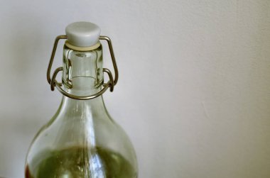 Şeffaf cam şişe tarafsız beyaz zemin üzerinde. Su dolu, kapanış mekanizması conta ve kap.