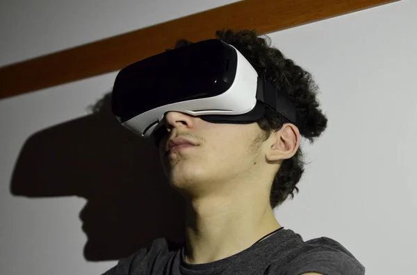 Un joven caucásico lleva el visor VR 360 en su habitación —  Fotos de Stock