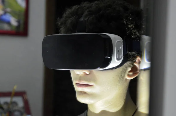 Um jovem caucasiano usa o visualizador VR 360 em seu quarto — Fotografia de Stock