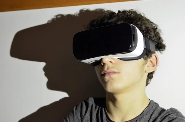 Un joven caucásico lleva el visor VR 360 en su habitación —  Fotos de Stock