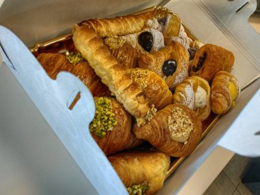 Cannoli, kruvasan ve kruvasan bir pasta kutusu dolu