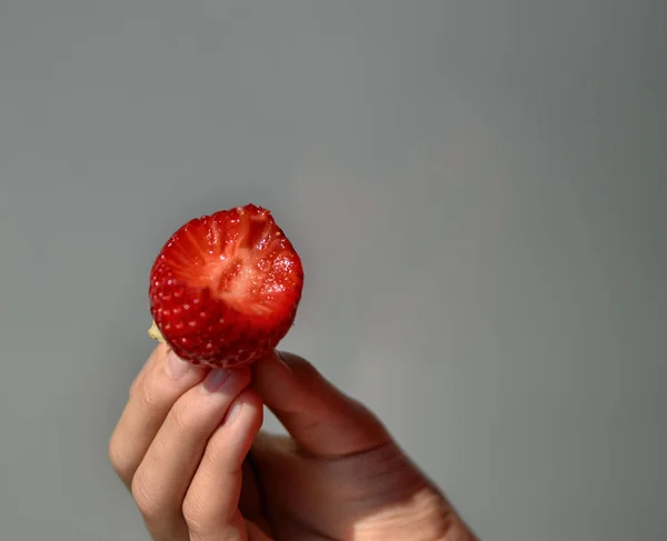 Hand stützt eine Erdbeere — Stockfoto