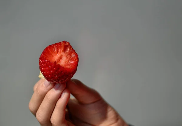 Hand stützt eine Erdbeere — Stockfoto