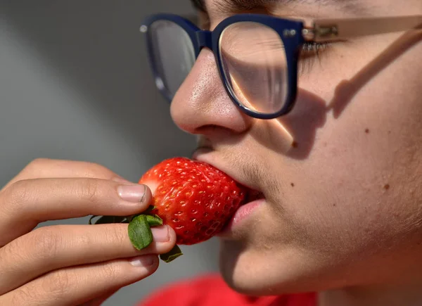 Καυκάσιος παιδί με τα γυαλιά που τρώει μια φράουλα — Φωτογραφία Αρχείου