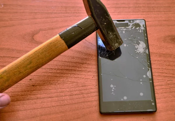 The tip of the hammer hit the screen of the smartphone