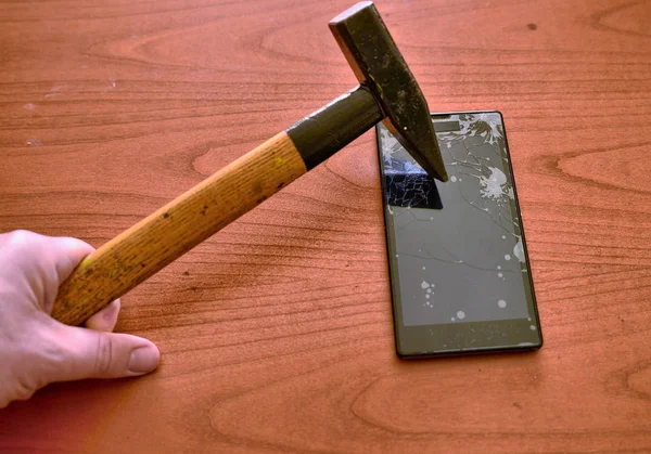 Кончик молотка попал в экран смартфона — стоковое фото