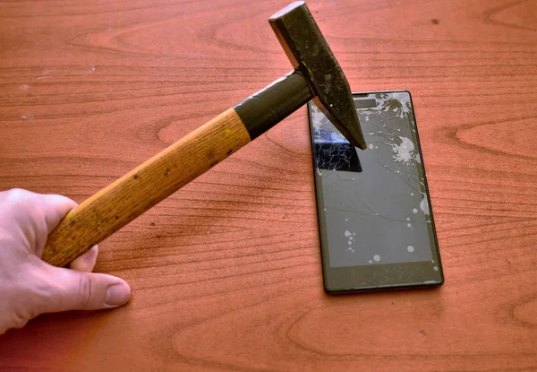 The tip of the hammer hit the screen of the smartphone