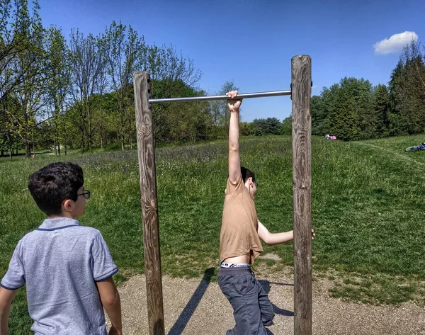 Caucasian boy tries his hand at pulling up the bar — Stock Image Caucasian boy tries his hand at pulling up the bar Stock Photo