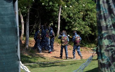 Paintball'da savaş. Genç oyuncular küçük bir grup, tam donatmak