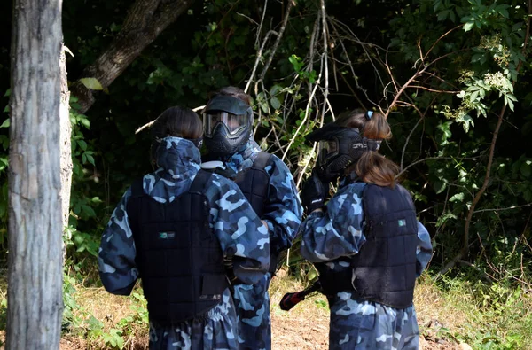 Batalla en paintball. Un pequeño grupo de jugadores jóvenes, totalmente equipados — Foto de Stock