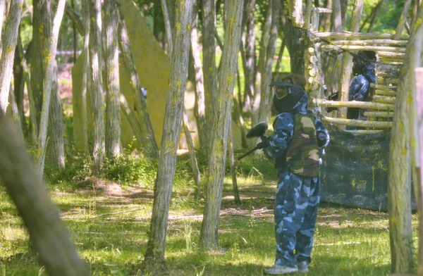 Batalla de paintball. Los jugadores aprovechan el bosque para acechar a un — Foto de Stock