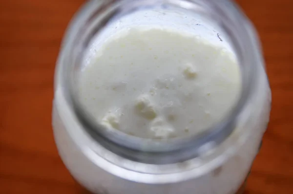 Close-up shot of a glass jar filled with fermenting kefir — Stock Photo, Image