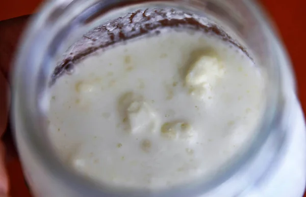 Närbild skott av en glasburk fylld med fermenterande kefir — Stockfoto