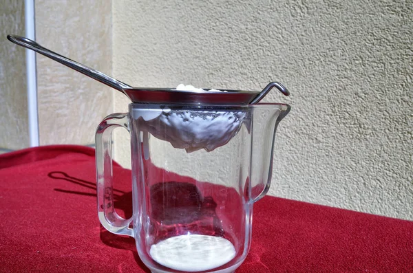 Kefir filtering with a net strainer. — Stock Photo, Image