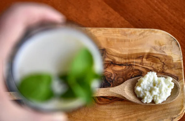 Nahaufnahme eines Glases voll Kefir mit Minzblättern — Stockfoto