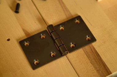 İki açık ahşap tahta üzerinde siyah metal menteşe