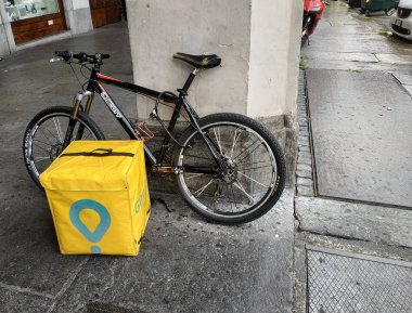 Torino, Piemonte, İtalya. Ağustos 2019. Glovo, hazır gıdalar eve teslim şirketi bir işçinin bisiklet ve teslimat çantası.