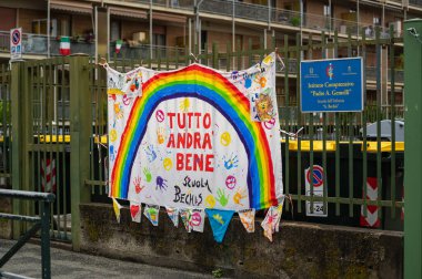 Torino, Piedmont, İtalya. Mayıs 2020. Koronavirüs salgını. Evlerin ön cephesinde gökkuşağının çizimiyle çarşafları asın ve her şey yoluna girecek..