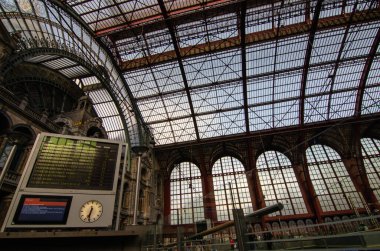 Antwerp, Flanders, Belçika. Ağustos 2019. İstasyonun tarihi girişini geçtikten sonra, tren varış yerini bulduk. Saatli büyük elektronik levha açıkça görülüyor..