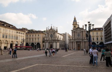 Torino, Piedmont, İtalya. Mayıs 2020. San Carlo Meydanı 'nda yürüyen insanların görüntüleri. Yoldan geçenlerin bazılarında, sizi koronavirüsten korumak için yüzünüzdeki maskeyi fark edersiniz. Arka planda ikiz kiliseler var.
