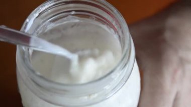 Kefir 'in dökülmesi sırasında yanal görüş. Granüller muhafaza edilirken elek ağından gelen mayalanmış süt açıkça görülebilir.