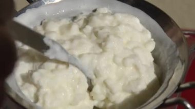 Kefir 'in kevgire döktüğü yakın çekim, filtrelemeyi kolaylaştırmak için çay kaşığı..