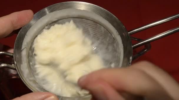 ケフィアのことだ 発酵牛乳と顆粒の混合物は ザルに注ぐことによって処理されます — ストック動画
