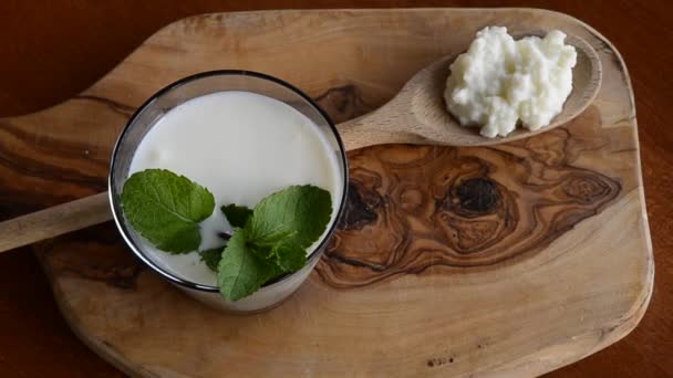 Primer Plano Vaso Lleno Kéfir Blanco Enriquecido Con Algunas Hojas — Vídeos de Stock