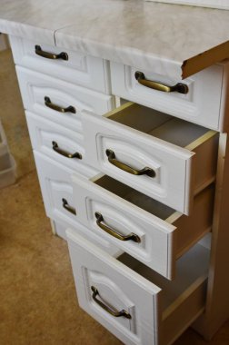 Kat komidin beyaz kutuları ve bakır kolları dolu. Kısmen çıkardı kutuları