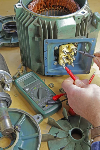 Three phase induction   motor bearing repair  A fitter/technician  removing rotor from stator  prior to changing shaft bearings