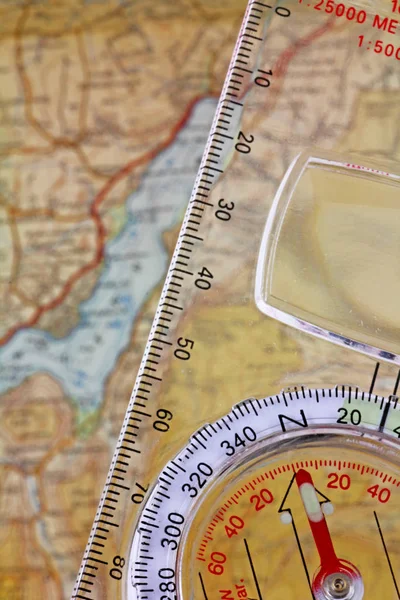 Compass and  map -  A compass with a set bearing being lined up above a map