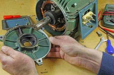 Üç fazlı endüksiyon motor taşıyan onarmak bir tesisatçı/teknisyen şaft yatakları değiştirme önce statör rotor kaldırılıyor