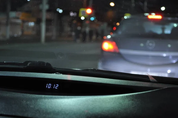 下午10 晚上在城里开车 查看汽车的前面板与时钟 — 图库照片